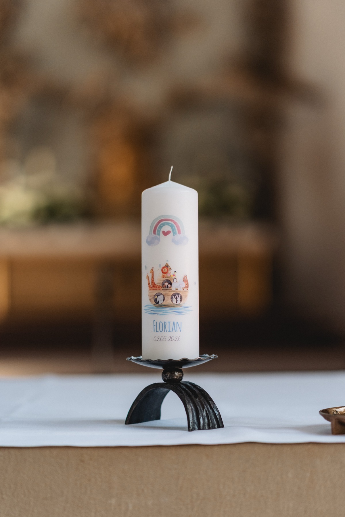 Taufe – persönlich gestaltete Taufkerze mit Namen auf dem Altar der Kirche