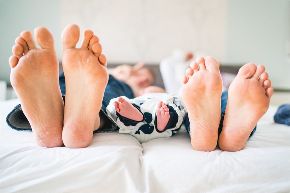 Familienfoto – Füße von Eltern und Neugeborenem