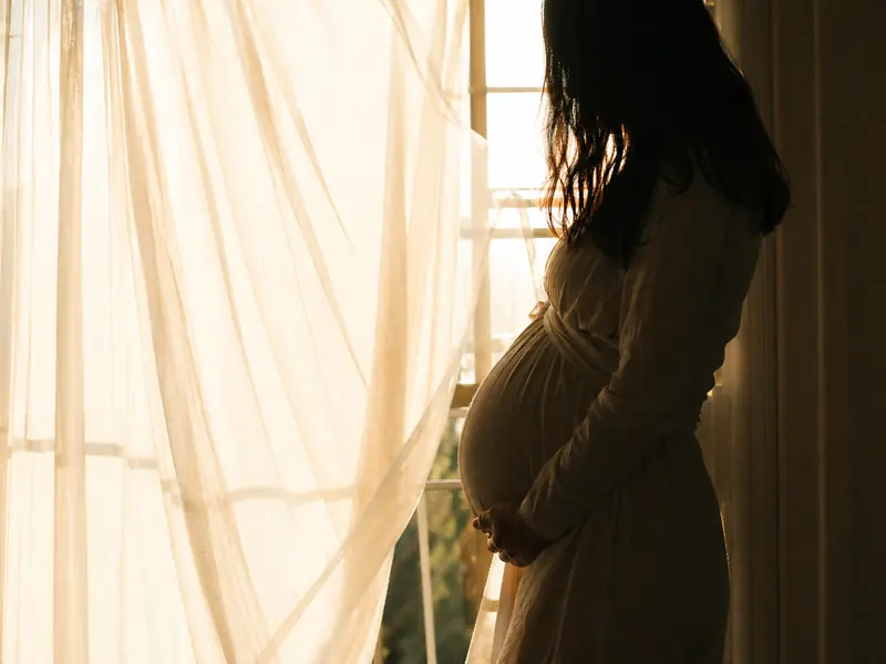 Silhouette einer Schwangeren im Gegenlicht